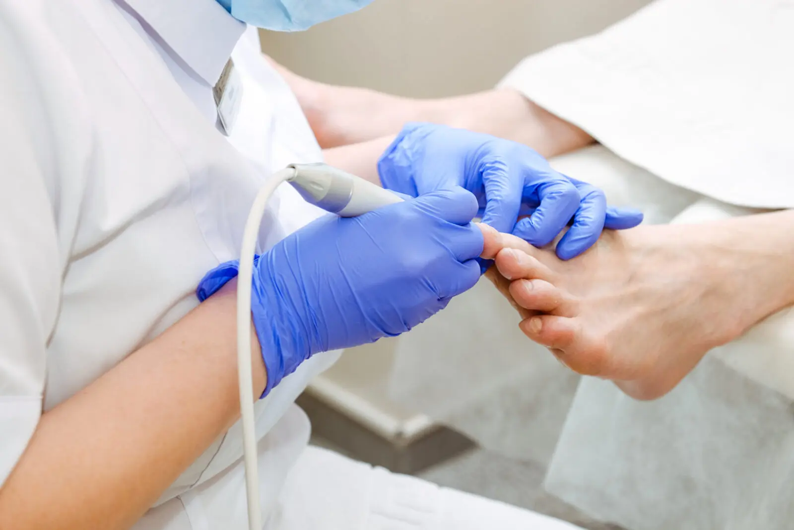 Diabetic Foot Care - Master chiropody shapes the nails . Male patient in the process of hardware pedicure procedure. Concept body care. Close up, selective focus